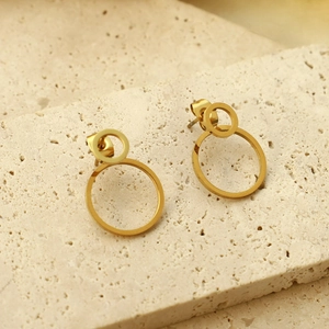 Minimalistische matte goldene runde hohle Ohrhänger auf Naturstein Hintergrund