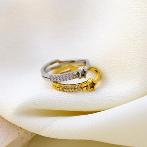 Star-shaped titanium steel rings with cubic zirconia inlay on elegant satin fabric