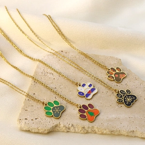 Gold paw print necklace set with colorful enamel Christmas heart patterns
