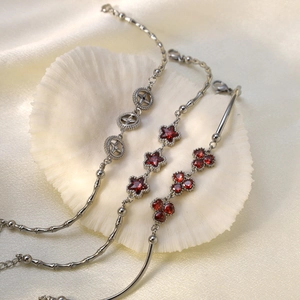 Three elegant vintage silver bracelets with red crystal charms and emerald glass accents