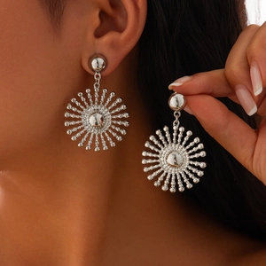 Gros plan de boucles d'oreilles tournesol en argent avec texture métal plissée sur modèle