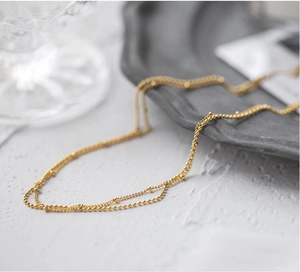 Minimalist double layered gold bead choker necklace with bright metallic finish for women