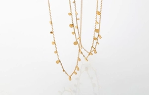 Detailed view of layered gold collar necklaces with geometric circles and rectangular charms