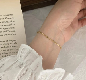Close-up of elegant 18K gold-plated twist chain bracelet on a woman's wrist
