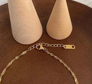 Detail of twisted 18K gold plated stainless steel chain with lobster clasp and D-tag