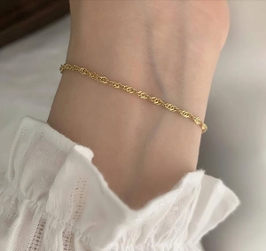 Minimalist 18K gold plated twisted rope chain bracelet on woman's wrist with lace