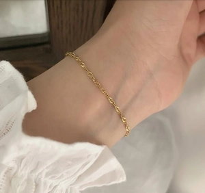 Elegant 18K gold plated twisted rope chain bracelet on female wrist with white lace