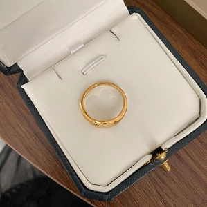 Bague chevalière en titane plaqué or 18K dans un écrin élégant sur fond de bois
