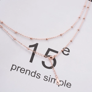 Detail of rose gold satellite chain necklace featuring tiny beads and lobster clasp