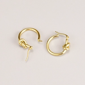 Detalle de pendientes de aro con nudo bañados en oro de acero inoxidable elegante