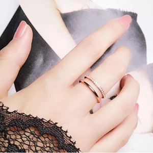 Zweilagiger Ring aus Roségold-Titanstahl mit Mikropavé-Kristallen an der Hand des Modells