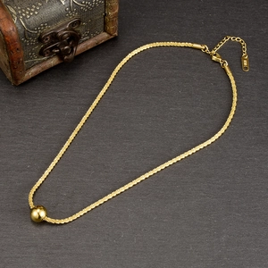 Macro detail of 18K gold ball pendant necklace with lobster clasp and K18 engraving