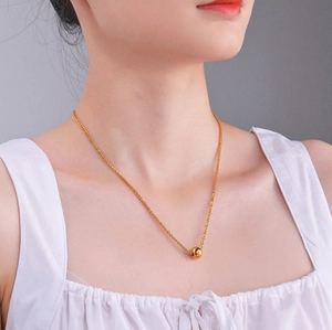 Elegant gold titanium ball pendant necklace on woman neck with minimalist rope chain