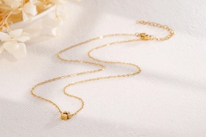 Collana minimalista dorata con ciondolo a zampa di gatto traforata su catena sottile