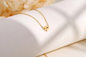 Collana minimalista dorata con ciondolo a zampa traforata su catenina a maglia O
