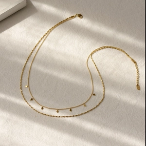 Detail einer 18k Gold-Doppelschicht-Halskette mit Rauten-Pailletten und Gliederkette