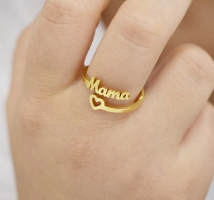 Nahaufnahme eines goldenen verstellbaren Mama-Rings mit Herz an einer Frauenhand