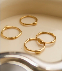 Makro-Detail von minimalistischen 18K Goldringen mit geschmolzener Textur in Keramik