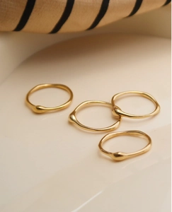 Detail von 18K vergoldeten Ringen mit organischen Wellenkanten und Perlenverzierung