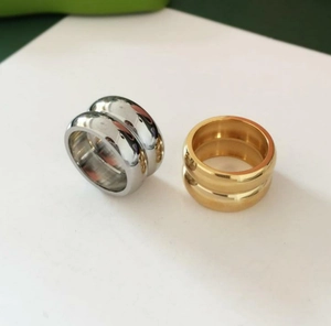 Nahaufnahme zweischichtiger breiter Ringe aus gold und silber poliertem Edelstahl