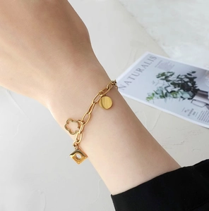 Chic 18k gold-plated daisy floral and geometric charm bracelet on woman's wrist