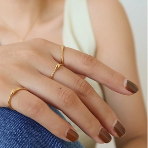 Set mit drei minimalistischen, 18K vergoldeten Edelstahlringen mit organischer Lava-Textur