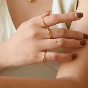 Dreiteiliges stapelbares 18K Goldring-Set mit Tropfendesign an der Hand einer Frau