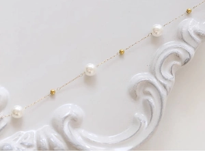 Elegante cavigliera in acciaio al titanio placcato oro 18K con perle bianche per donna
