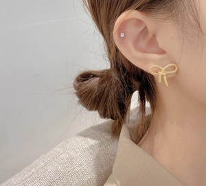 Élégantes boucles d'oreilles nœud en or 18 carats avec texture métallique sur un modèle
