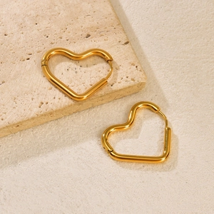 Élégantes boucles d'oreilles cœur en acier titane poli sur une texture de pierre