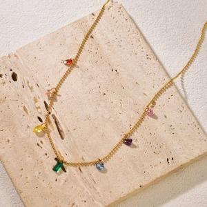 Detail of gold beaded necklace with seven colorful teardrop-shaped zircon pendants