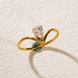Macro shot of V-shaped 18K gold ring featuring a pear-cut sparkling zircon setting