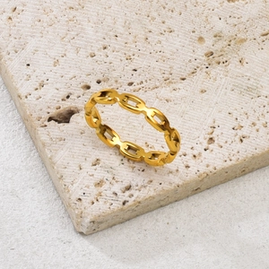 Polierter goldener hohler Kettengliedring aus Edelstahl auf einer Steinplatte präsentiert