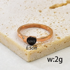 Rose gold heart ring with LOVE engraving and tiny zircon on a stone display