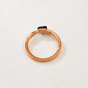 Close-up of rose gold ring with layered heart design and black heart inlay detail