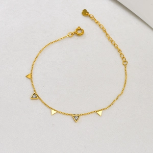 Detail of 18K gold geometric bracelet featuring delicate triangle pendants and zircons