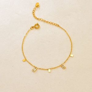 Detailed close-up of 18K gold geometric bracelet with square zircons and spring clasp