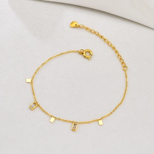 Detail of 18K gold bracelet with geometric square rhinestones and heart tag extension