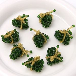 Detailed view of handmade dark green crystal beaded rice dumpling charms with gold accents