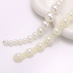 Detailed close-up of faux pearl shoe chains and elegant white bead charms