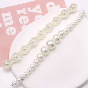 Detail of DIY pearl chains for clogs featuring wavy and gradient sizes on a ceramic tray