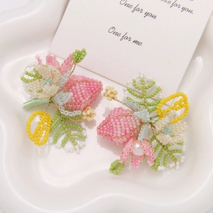 Dettaglio di orecchini a fiore fatti a mano con perle su vassoio in ceramica a stella