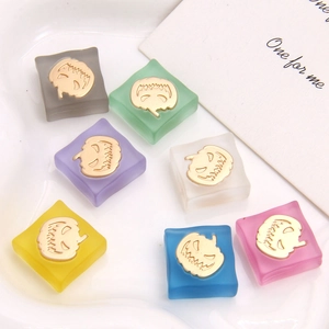 Macro shot of colorful frosted resin square charms with golden pumpkin face detail
