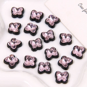 Vue détaillée de breloques papillon avec cristaux roses et socles en résine noire pour DIY
