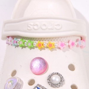 Macro detail of colorful macaron star beads and shiny resin charms for clog shoes decor