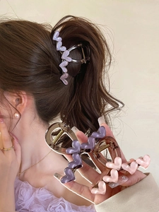 Dettaglio di fermagli per capelli a cuore in resina glitterata in colori rosa e viola