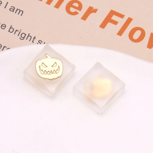 Close-up of translucent square resin earrings with gold pumpkin charms for Halloween