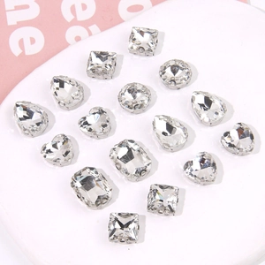 Macro shot of assorted faceted clear rhinestones in silver claw settings for DIY crafts