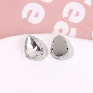 Macro detail of tear-drop crystal rhinestone with silver metal claw base for DIY shoe charms