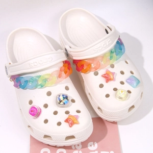 White clogs decorated with rainbow gradient chains and sparkling rhinestone charms